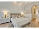 Bright main bedroom with white wainscoting walls, hardwood floors, and designer furniture at 52 Grande Fairway, Englewood, FL 34223