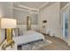 Bright main bedroom with hardwood floors, wainscoting, access door, and designer furniture at 52 Grande Fairway, Englewood, FL 34223