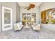 Covered patio with comfortable seating, a ceiling fan, and a view of the screened-in backyard at 52 Grande Fairway, Englewood, FL 34223