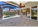 Screened-in pool and spa with lush landscaping, a covered patio, and a view of the home's exterior at 52 Grande Fairway, Englewood, FL 34223
