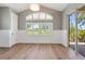 Bright room with hardwood floors, large windows with plantation shutters, and access to the outdoor patio at 52 Grande Fairway, Englewood, FL 34223