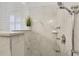 Close-up of marble shower with dual shower heads, a built-in seat and soap dish, with shuttered window nearby at 52 Grande Fairway, Englewood, FL 34223