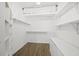 Walk-in closet with built-in shelving and wooden floors for optimal storage and organization at 5226 Magnolia Pond Dr, Sarasota, FL 34233
