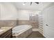 Main bathroom featuring a soaking tub, and walk-in glass block shower with tile surround at 5226 Magnolia Pond Dr, Sarasota, FL 34233