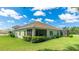 Backyard view shows the house, covered patio, nice lawn, and green landscaping at 5450 Fairfield Blvd, Bradenton, FL 34203