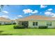 Backyard of the house with screened lanai, green lawn, and lush landscaping at 5450 Fairfield Blvd, Bradenton, FL 34203