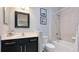 Well-lit bathroom features a shower-tub combo, dark vanity, and framed mirror at 5450 Fairfield Blvd, Bradenton, FL 34203