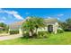 Inviting single-story home featuring a lush lawn, verdant plantings, and attractive neutral-toned exterior paint at 5450 Fairfield Blvd, Bradenton, FL 34203