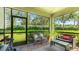 Enclosed patio with comfortable seating, plants, and view of the landscaped backyard at 5450 Fairfield Blvd, Bradenton, FL 34203