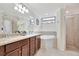 Bathroom featuring dual sinks, a bathtub and a glassed-in shower, offering a spa-like experience at 5624 Palmer Cir # 101, Bradenton, FL 34211