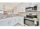 Well-lit kitchen featuring stainless steel appliances, granite counters, and white cabinets at 5624 Palmer Cir # 101, Bradenton, FL 34211