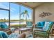Screened lanai featuring comfortable seating, a glass table, and a peaceful water view at 5624 Palmer Cir # 101, Bradenton, FL 34211