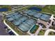 Aerial view showcasing multiple well-maintained tennis courts surrounded by lush landscaping and a clubhouse at 5624 Palmer Cir # 101, Bradenton, FL 34211