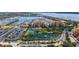 Stunning aerial view of a waterfront condo building with a marina, lake, and tennis courts at 606 Riviera Dunes Way # 306, Palmetto, FL 34221