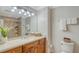 Bathroom featuring vanity, a well-lit mirror, and a separate toilet area at 606 Riviera Dunes Way # 306, Palmetto, FL 34221