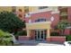 Attractive building entrance featuring covered drop-off, glass doors, and mature landscaping at 606 Riviera Dunes Way # 306, Palmetto, FL 34221