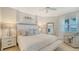 Bright main bedroom with a king bed, two nightstands, a mirror, and coastal views at 606 Riviera Dunes Way # 306, Palmetto, FL 34221