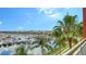 Breathtaking marina view from balcony, framed by lush palm trees, creating a serene tropical ambiance at 606 Riviera Dunes Way # 306, Palmetto, FL 34221