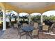 Outdoor seating area with tables, chairs, ceiling fans, and a grill with views of the harbor and tropical landscape at 606 Riviera Dunes Way # 306, Palmetto, FL 34221