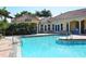 Inviting community pool with ample lounge chairs, landscaped grounds, and shade at 606 Riviera Dunes Way # 306, Palmetto, FL 34221