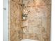 Tiled shower featuring a handheld shower head and convenient built-in shelves at 606 Riviera Dunes Way # 306, Palmetto, FL 34221