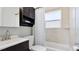 Bathroom features a combination tub and shower with a built in shelf and cabinet at 6423 Georgia Ave, Bradenton, FL 34207