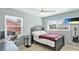Cozy bedroom with a black bedframe, desk, ceiling fan and a wall mounted TV, creating a comfortable and stylish space at 6423 Georgia Ave, Bradenton, FL 34207