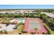 A clear view of a pool, tennis court, palm trees, and community area surrounded by single Gathering homes at 6462 Draw Ln # 72, Sarasota, FL 34238