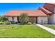 Charming single-story home with a well-manicured lawn and vibrant landscaping with an orange roof at 6462 Draw Ln # 72, Sarasota, FL 34238