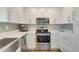 Bright kitchen features white cabinets, stainless appliances, and a stylish tile backsplash at 6462 Draw Ln # 72, Sarasota, FL 34238