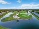 Expansive golf course community featuring waterways, manicured greens, and residential buildings under a clear sky at 6999 W Country Club N Dr # 224, Sarasota, FL 34243