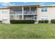 Spacious backyard with lush green grass, manicured hedges, and a view of the rear of the building at 6999 W Country Club N Dr # 224, Sarasota, FL 34243