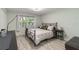 Bedroom with sleek black metal bed and wood-look tile floors at 6999 W Country Club N Dr # 224, Sarasota, FL 34243