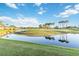 Scenic golf course view featuring a tranquil pond and lush green fairways dotted with palm trees under a bright sky at 6999 W Country Club N Dr # 224, Sarasota, FL 34243