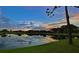 Picturesque sunset reflecting on the tranquil pond, with lush green grass in the foreground at 6999 W Country Club N Dr # 224, Sarasota, FL 34243