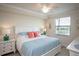 Bright bedroom with a white bed, ceiling fan, and serene views from the window at 7005 River Hammock Dr # 204, Bradenton, FL 34212