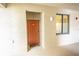 Front door entrance with orange door, welcome mat, and sidelight window at 7005 River Hammock Dr # 204, Bradenton, FL 34212