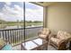 Screened lanai with comfortable seating overlooks a tranquil lake and lush greenery for relaxation at 7005 River Hammock Dr # 204, Bradenton, FL 34212