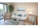 Comfortable living room featuring a white sofa, patterned armchairs, and access to balcony at 7005 River Hammock Dr # 204, Bradenton, FL 34212