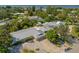 This aerial showcases a home with a modern metal roof and a screened-in pool, nestled in a serene, tree-filled neighborhood at 7202 18Th Nw Ave, Bradenton, FL 34209