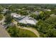 Aerial view of a well-maintained home featuring lush greenery, a metal roof, and a spacious driveway at 7202 18Th Nw Ave, Bradenton, FL 34209