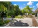 Backyard garden with a mix of tropical foliage, small palm trees, and a gravel ground cover at 7202 18Th Nw Ave, Bradenton, FL 34209