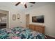 Bedroom with tropical bedding, ceiling fan, television, and ensuite access at 7202 18Th Nw Ave, Bradenton, FL 34209