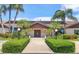 Beautiful clubhouse entrance with manicured hedges, palm trees, and accessible parking, creating a welcoming atmosphere at 7301 29Th Avenue W Dr # 108, Bradenton, FL 34209