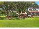 Community picnic area with multiple picnic tables under a canopy of mature trees on a large green lawn at 7301 29Th Avenue W Dr # 108, Bradenton, FL 34209