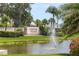Community sign amidst lush landscaping and a serene pond with fountain feature at Country Village, 55+ Community at 7301 29Th Avenue W Dr # 108, Bradenton, FL 34209