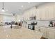 Bright kitchen boasts white cabinets, granite counters, and stainless appliances at 7844 52Nd E Ter, Bradenton, FL 34203