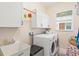 Bright laundry room with white cabinets, washer, dryer, and sink at 7844 52Nd E Ter, Bradenton, FL 34203