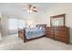 Main bedroom with a ceiling fan, tapestry, large window, and a comfortable bed at 7844 52Nd E Ter, Bradenton, FL 34203