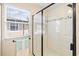 Modern glass-enclosed shower with white tile and a window for natural light at 7844 52Nd E Ter, Bradenton, FL 34203